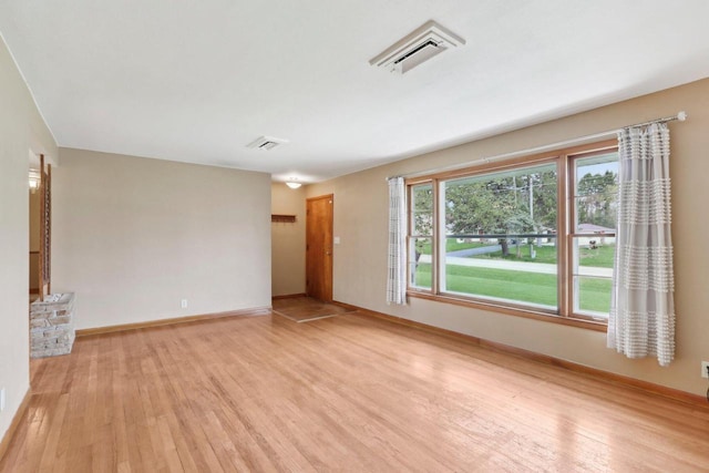 unfurnished living room featuring light wood-type flooring, baseboards, and visible vents