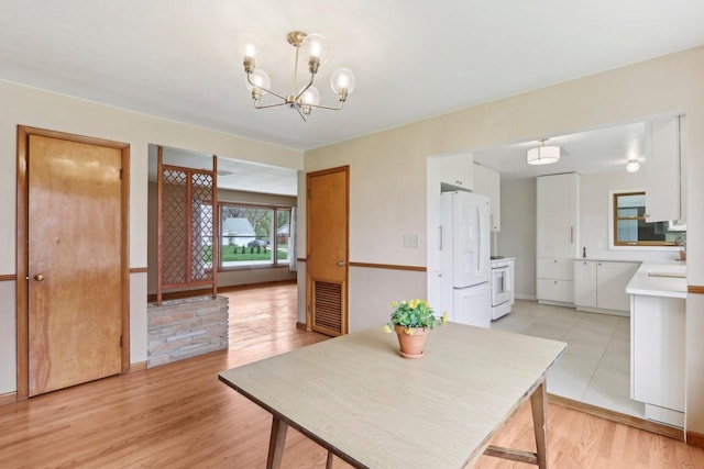 dining space with visible vents, light wood finished floors, and a notable chandelier