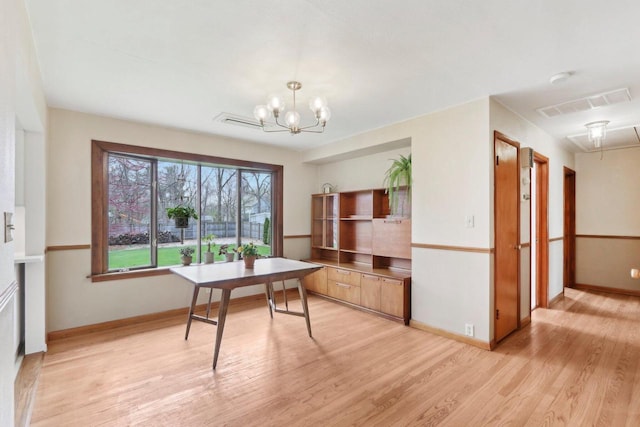 dining space featuring baseboards, a notable chandelier, light wood finished floors, and visible vents