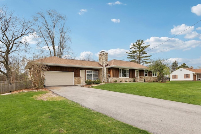 ranch-style home with aphalt driveway, a chimney, a garage, fence, and a front lawn