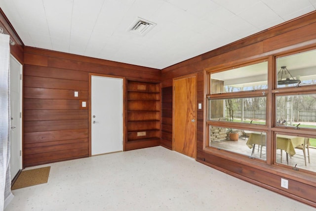 entrance foyer featuring wood walls and visible vents