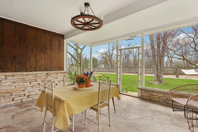 sunroom / solarium with a ceiling fan and outdoor dining space