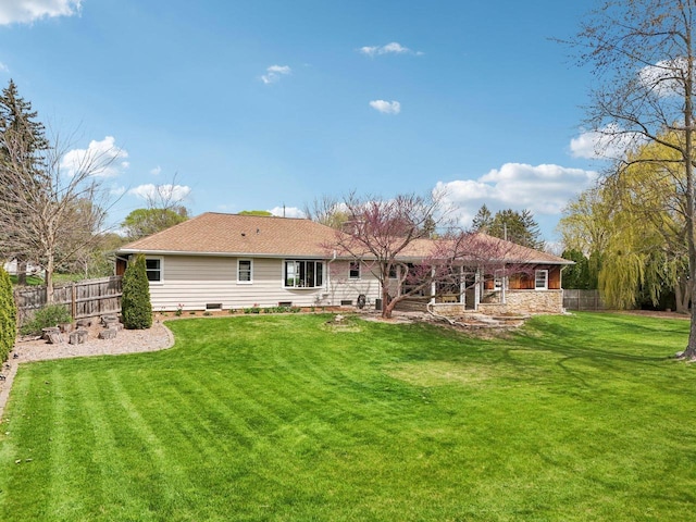 rear view of property with a lawn, a fenced backyard, and crawl space