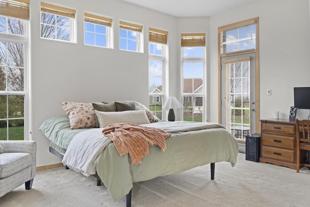 carpeted bedroom with baseboards and multiple windows