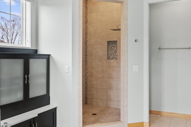 full bath with baseboards, a shower stall, and tile patterned floors