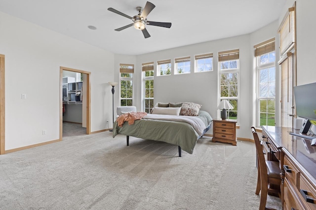 bedroom featuring baseboards, multiple windows, and light carpet