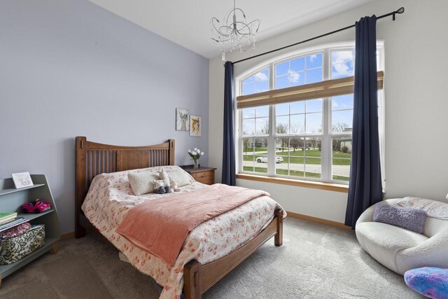 carpeted bedroom with baseboards and a chandelier