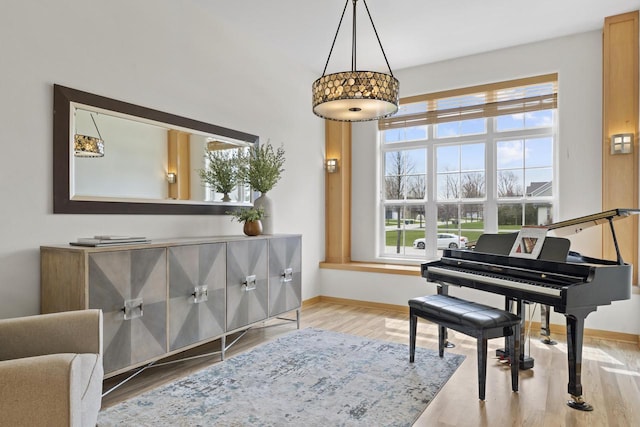 living area with baseboards, a wealth of natural light, and wood finished floors