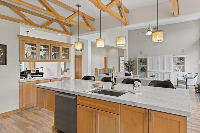 kitchen with stainless steel dishwasher, a kitchen island with sink, open floor plan, high vaulted ceiling, and a sink
