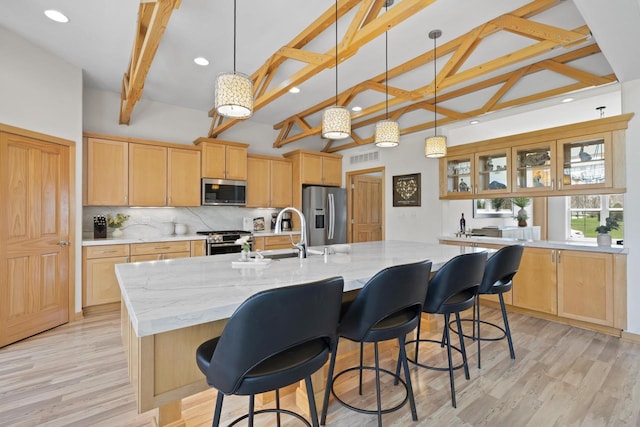 kitchen featuring lofted ceiling with beams, recessed lighting, tasteful backsplash, a sink, and appliances with stainless steel finishes