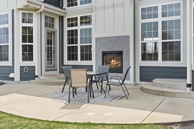view of patio / terrace featuring entry steps, outdoor dining space, and a tile fireplace