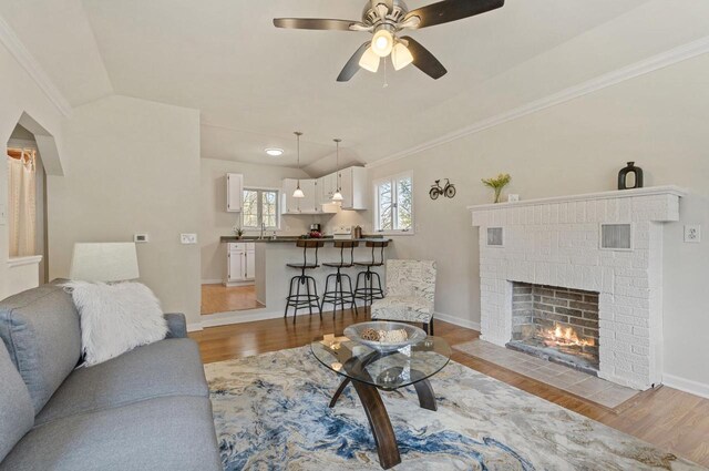 805 Manor Dr, Twin Lakes, WI 53181 - living area with crown molding, a brick fireplace, wood finished floors, and lofted ceiling