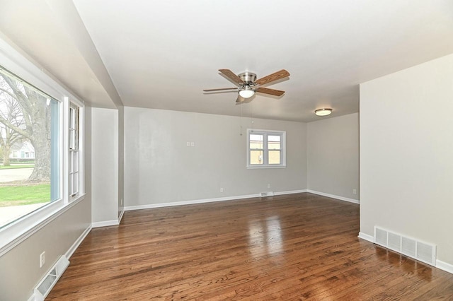 spare room featuring visible vents, ceiling fan, and wood finished floors