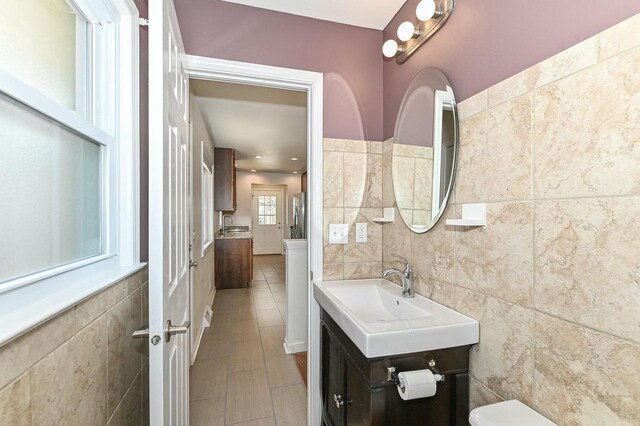 bathroom featuring tile patterned flooring, tile walls, and vanity