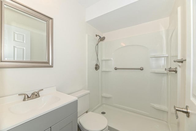 full bath featuring toilet, a shower, and vanity