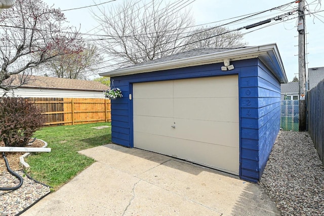 detached garage with fence and concrete driveway