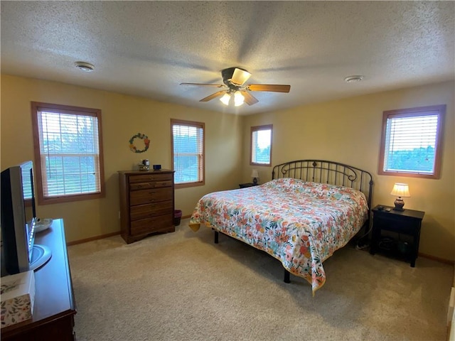 carpeted bedroom with baseboards, a ceiling fan, and a textured ceiling