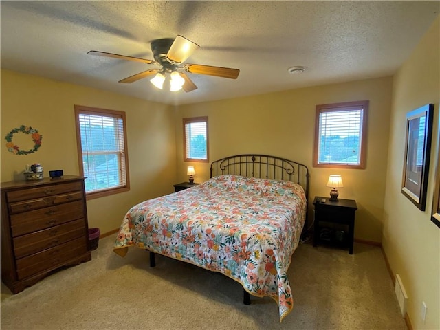 bedroom featuring a textured ceiling, visible vents, baseboards, carpet floors, and a ceiling fan