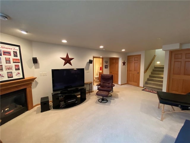living room with recessed lighting, stairs, light colored carpet, and a glass covered fireplace