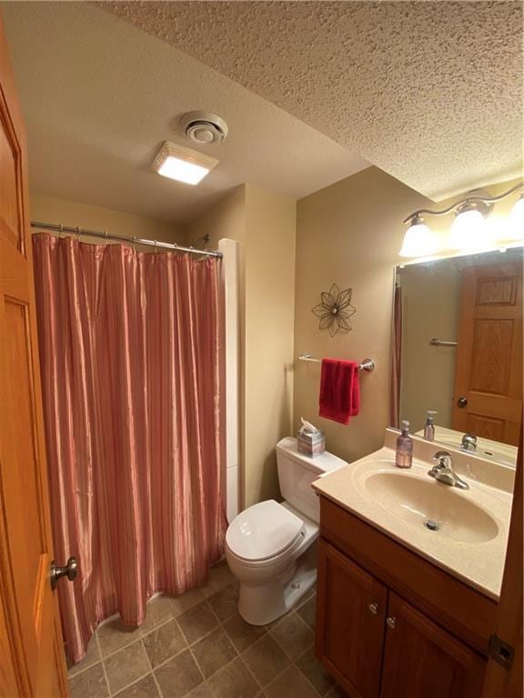 full bathroom with a shower with curtain, tile patterned flooring, vanity, toilet, and a textured ceiling