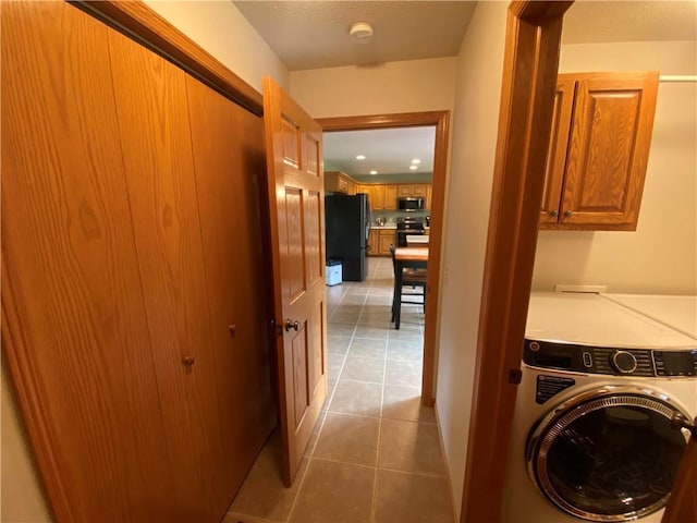laundry room featuring recessed lighting, cabinet space, light tile patterned floors, washer / dryer, and baseboards