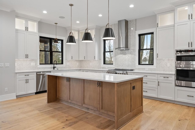 N1931 Linn Rd, Lake Geneva, WI 53147 - kitchen with wall chimney range hood, light countertops, a center island, stainless steel appliances, and decorative backsplash