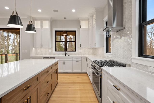 N1931 Linn Rd, Lake Geneva, WI 53147 - kitchen with light countertops, light wood-style flooring, wall chimney exhaust hood, stainless steel appliances, and backsplash