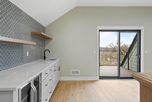 N1931 Linn Rd, Lake Geneva, WI 53147 - interior space with visible vents, wine cooler, a sink, baseboards, and light wood-style floors
