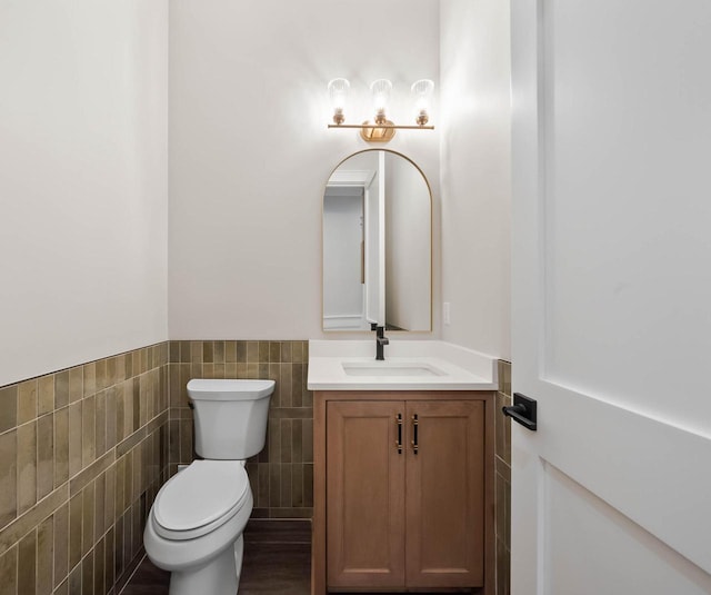 N1931 Linn Rd, Lake Geneva, WI 53147 - half bathroom featuring vanity, a wainscoted wall, toilet, and tile walls