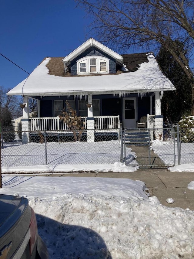 view of front of property with a porch, a fenced front yard, and a gate