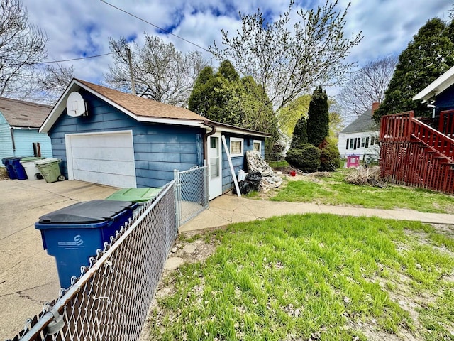 exterior space featuring a detached garage, fence, and an outdoor structure