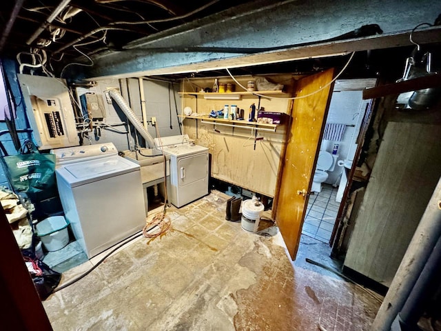 laundry room featuring laundry area, washer and clothes dryer, a sink, and electric panel