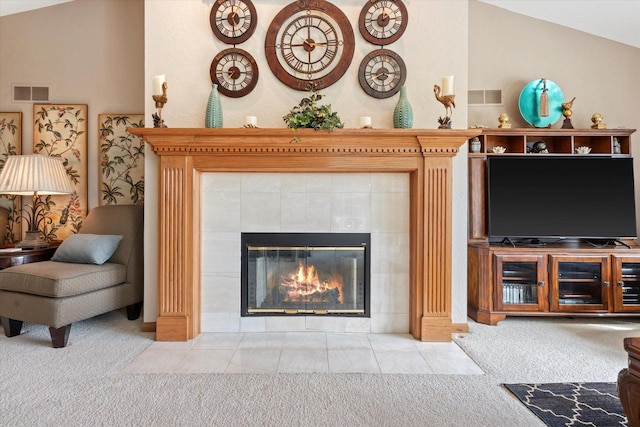 carpeted living room featuring visible vents, a tiled fireplace, and vaulted ceiling