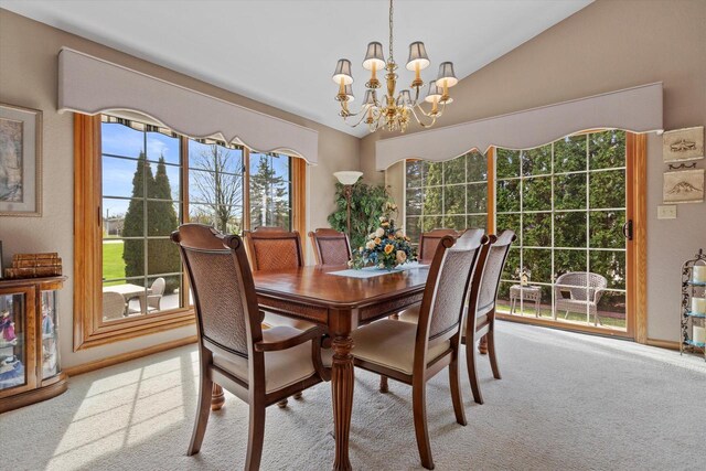 carpeted dining area with vaulted ceiling and a chandelier