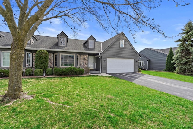 new england style home with driveway, roof with shingles, and a front lawn