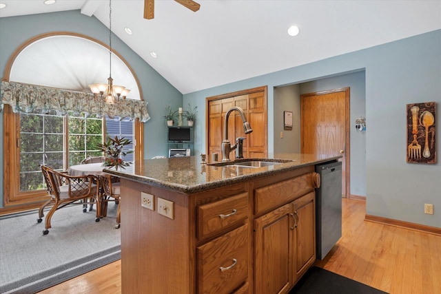 kitchen featuring light wood finished floors, a sink, lofted ceiling with beams, brown cabinetry, and stainless steel dishwasher