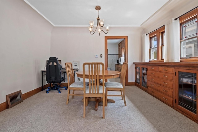 dining space featuring visible vents, baseboards, ornamental molding, light carpet, and a notable chandelier