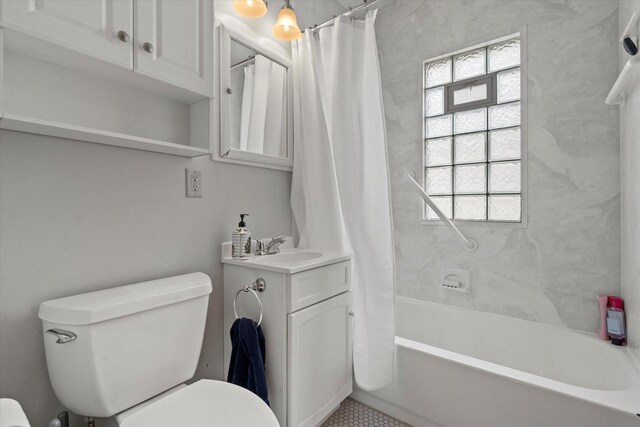 bathroom featuring shower / bathtub combination with curtain, toilet, and vanity