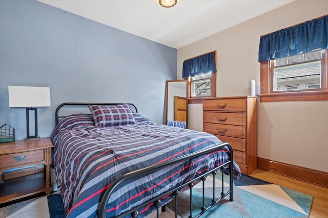 bedroom with wood finished floors and baseboards