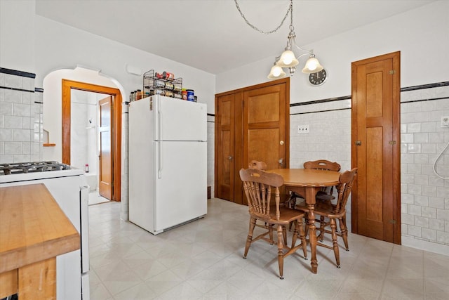 dining room with tile walls and light floors