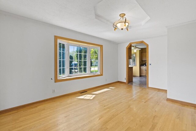 3559 N Shore Dr, Hubertus, WI 53033 - empty room with light wood-type flooring, baseboards, crown molding, a chandelier, and ceiling fan