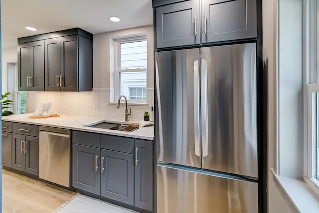 14 Wirth Ct, Madison, WI 53704 - kitchen featuring appliances with stainless steel finishes, a sink, backsplash, light wood-style floors, and recessed lighting