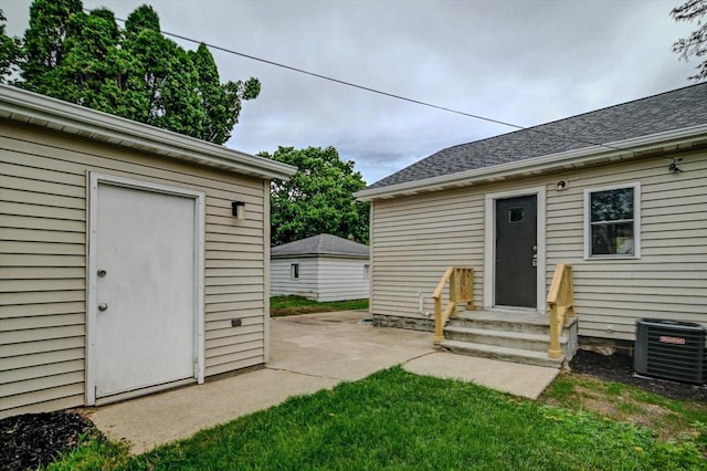 14 Wirth Ct, Madison, WI 53704 - property entrance featuring cooling unit, a patio area, a lawn, and roof with shingles