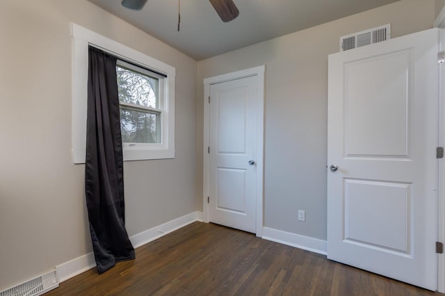 unfurnished bedroom with baseboards, a ceiling fan, dark wood-style flooring, and visible vents