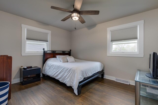 bedroom featuring baseboards, multiple windows, hardwood / wood-style floors, and visible vents