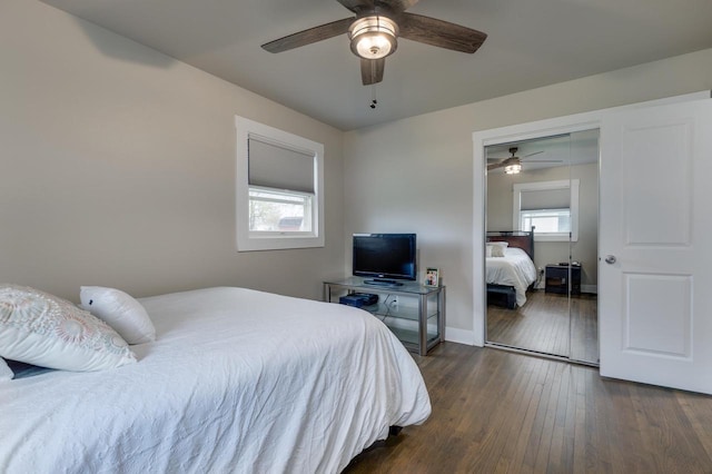 bedroom featuring baseboards, ceiling fan, a closet, and dark wood-type flooring