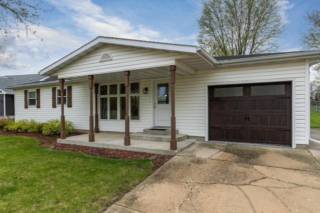 single story home with a garage, a front lawn, covered porch, and concrete driveway
