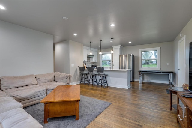 living room with recessed lighting, baseboards, and dark wood-style floors