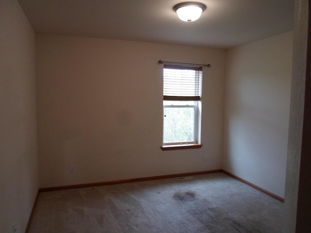 spare room with baseboards and carpet