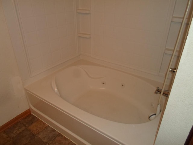 bathroom featuring baseboards and a whirlpool tub